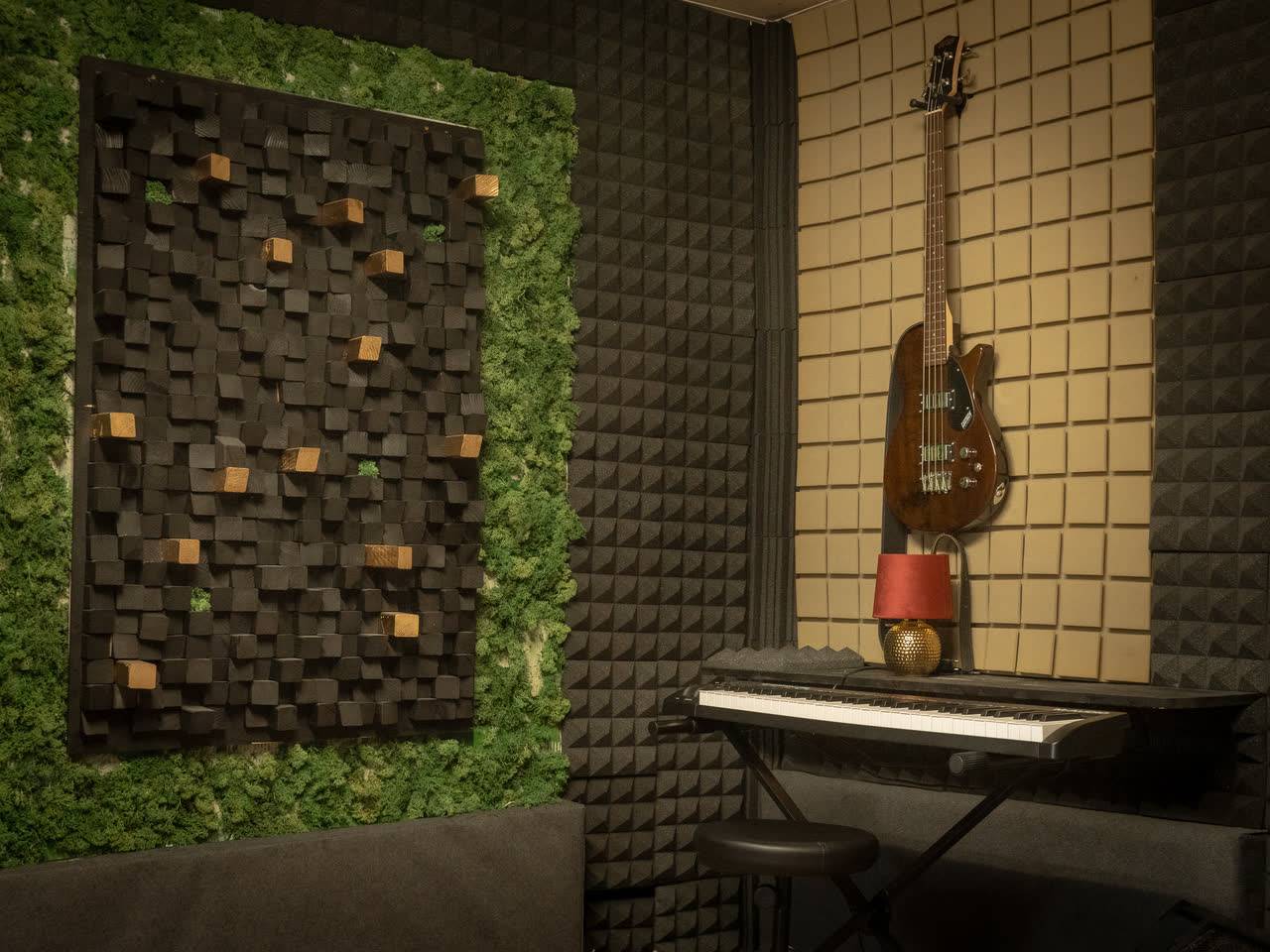 Recording-Ecke mit Bass und Akustikpanel bei Tageslicht