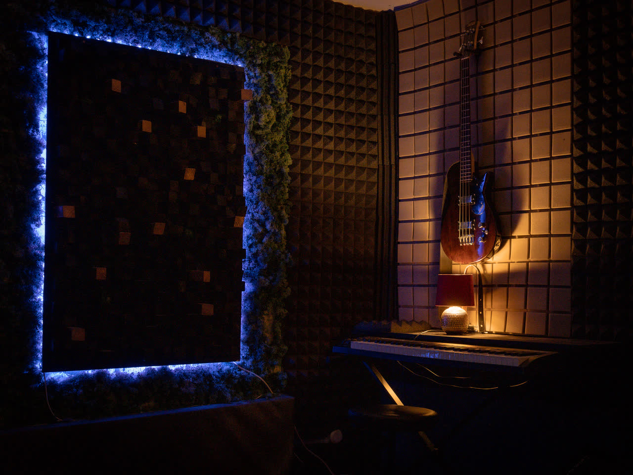 Recording-Ecke mit Bass und Akustikpanel im Studiolicht